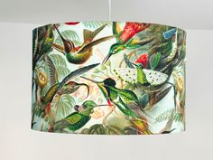 a lamp hanging from a ceiling in a room with hummingbirds and flowers on it