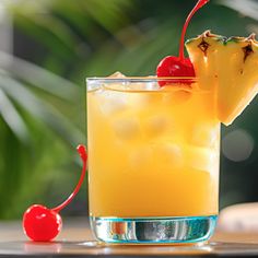 a pineapple drink with a cherry garnish on the rim