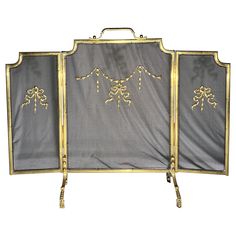 an ornately decorated fireplace screen with gold trimmings and bows on the sides