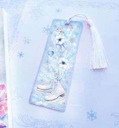 a bookmark with ice skates and flowers on it