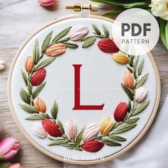 the letter l is surrounded by flowers and leaves on a white background with text overlay