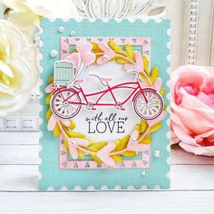 a close up of a card with flowers in the background and a bicycle on it