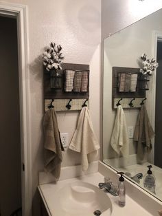 a white sink sitting under a bathroom mirror next to a wall mounted towel dispenser