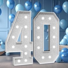 the number forty four is surrounded by blue and white balloons in front of a wall