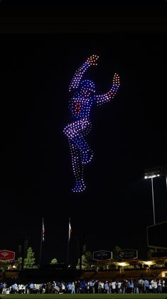 a baseball player is flying through the air in front of an american flag at night