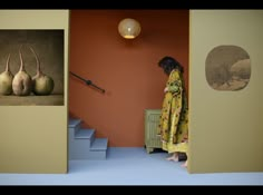 a woman standing in front of a doorway with three pears on the wall next to her