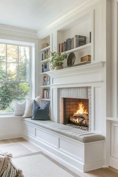 a living room with a fire place and bookshelves on the wall above it