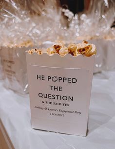 popcorn bags filled with popcorn sitting on top of a white tablecloth covered table cloth