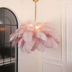 a pink chandelier hanging from the ceiling in front of a door with an arched window