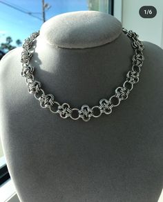 a close up of a silver necklace on a mannequin's neckline