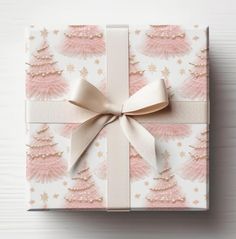 a present wrapped in pink and white paper with a bow