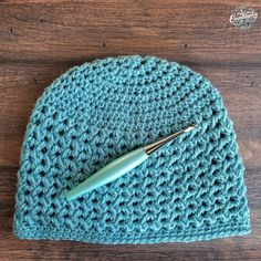 a crocheted beanie with a ball of yarn next to it