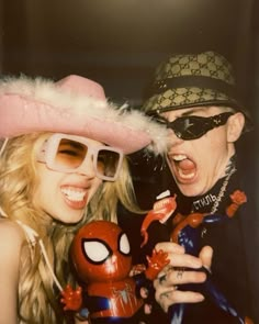 two people dressed up in costumes and hats posing for a photo with deadpool dolls