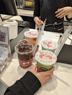 two people at a counter with cups of ice cream and coffee in front of them