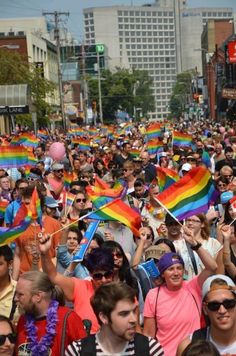 a large group of people holding rainbow flags