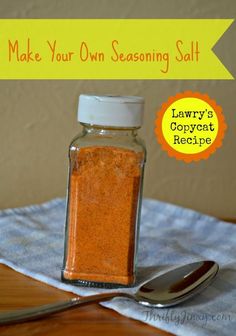 a jar filled with salt sitting on top of a wooden table next to a spoon