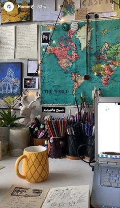 a laptop computer sitting on top of a desk covered in lots of books and papers