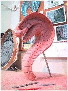 a pink sculpture sitting on top of a table next to a marker and pencils