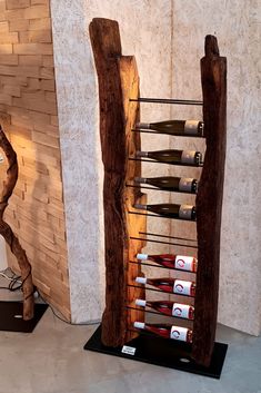 a wine rack made out of wood with bottles on it in front of a wall