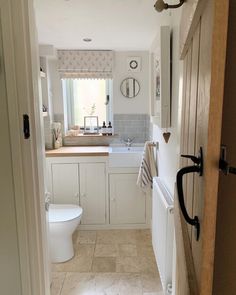 a bathroom with a toilet, sink and mirror in it's doorway way to another room