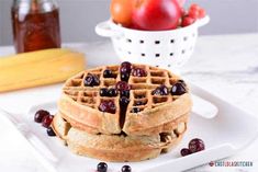 a white plate topped with waffles covered in fruit