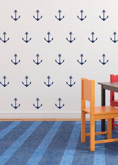 a child's room with an anchor decal on the wall and a table