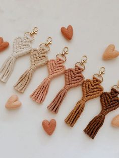 several tasseled key chains with hearts hanging from each one on a white surface