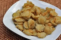 a white plate topped with fried food on top of a table