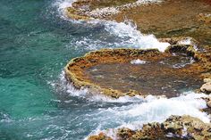 the water is blue and green with white foamy waves coming up on it's surface