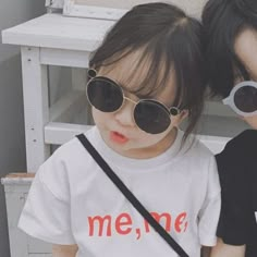 two young children wearing sunglasses sitting next to each other