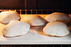 six uncooked doughnuts sitting on top of an oven rack