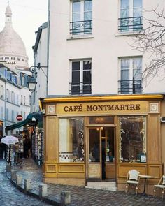 an old fashioned cafe in the middle of a cobblestone street