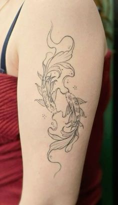 a woman with a tattoo on her arm is looking down at the water and goldfish