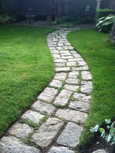 a stone path in the middle of a yard