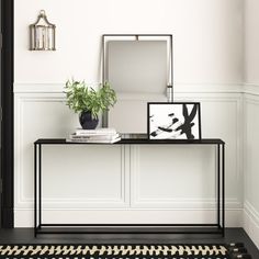 a black and white entryway with a plant on the table