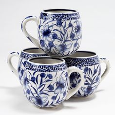 three blue and white coffee mugs sitting next to each other on a white surface