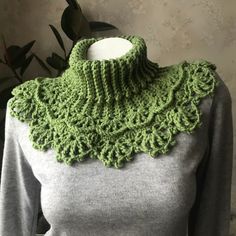 a green crocheted neck scarf on a mannequin