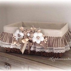 a basket that has flowers in it on top of a dresser drawer with lace around the edges