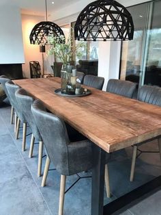 a large wooden table surrounded by grey chairs