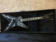 an electric guitar in a black case with lightning bolts painted on it's body