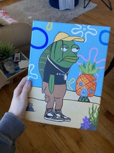 a person holding up a painting in their hand