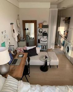 a living room filled with furniture and a washing machine in the back drop off area