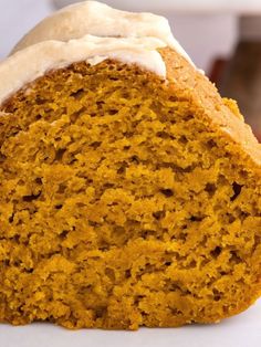 a loaf of pumpkin bread with white frosting on the top and side, sitting on a plate