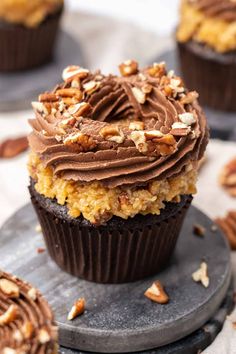 cupcakes with chocolate frosting and nuts on top