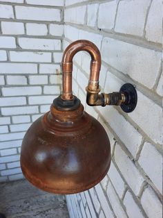 an old fashioned lamp hanging from the side of a brick wall