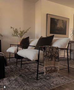 a living room filled with furniture and a rug on top of a hard wood floor