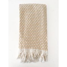 a beige and white towel with fringes on it