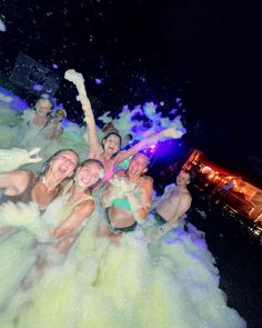 some people are having fun in the water and spraying them with colored powder on their faces