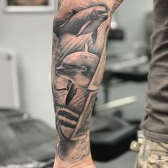 a man's arm with two dolphins on it