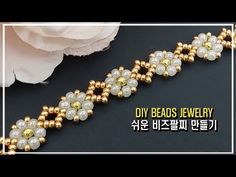 the beaded bracelet is decorated with pearls and gold beads, along with a white flower